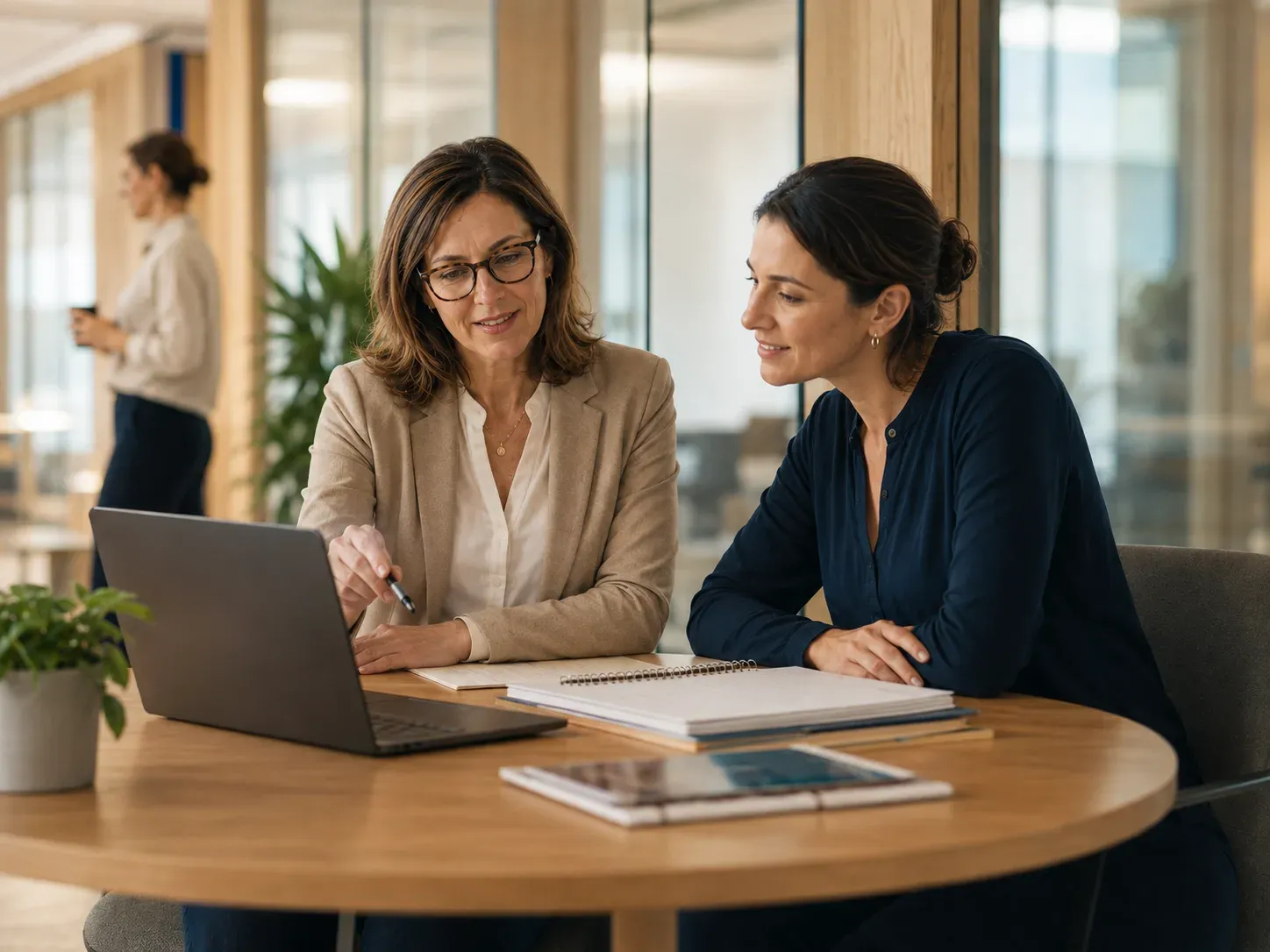 Deux professionnelles des ressources humaines collaborent autour d'un ordinateur portable dans un bureau moderne
